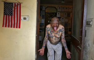 Guinness Rishi, 74, multiple world record holder including most flags tattooed on his body, poses for a photograph outside his apartment in New Delhi, India May 20, 2016. REUTERS/Cathal McNaughton TPX IMAGES OF THE DAY